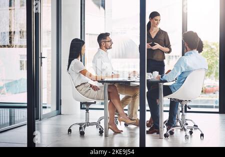 Success is so close within their grasp. a businesswoman giving a presentation to her colleagues in a boardroom. Stock Photo