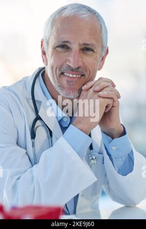 Healthcare is my passion. Portrait of a mature doctor sitting in a hospital. Stock Photo