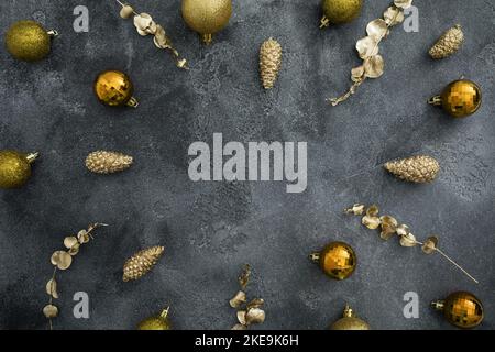 Holidays frame with golden Christmas decoration on dark background. Winter celebrations. Flat lay, top view Stock Photo