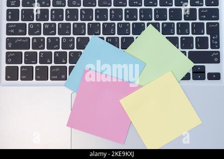 Colorful bank sticky notes laying over on a computer keyboard Stock Photo