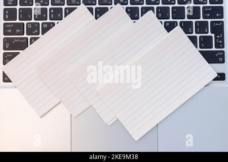 White blank business cards laying over on a laptop keyboard with copy space Stock Photo