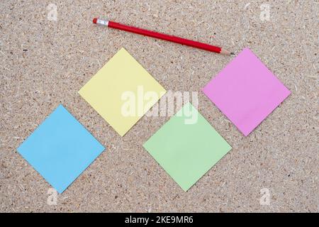 Blank sticky notes with a pencil on a corkboard background Stock Photo