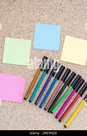 Empty sticky notes with colorful markers on wooden board Stock Photo