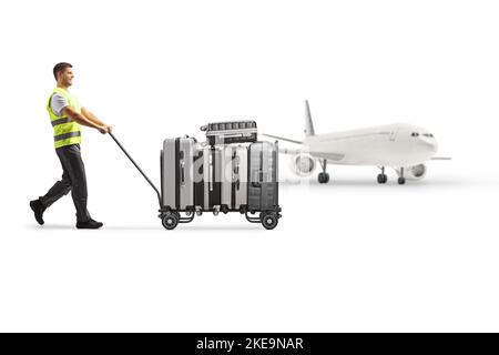 Airport worker pushing a luggage cart with suitcases toards an airplane isolated on white background Stock Photo