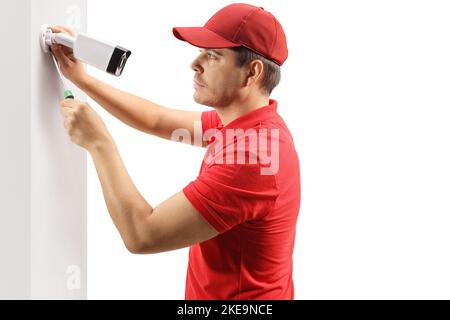 Profile shot of a young man installing a security camera on a wall Stock Photo