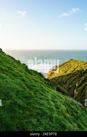 A beautiful coastal landscape with green rolling hills and cliffs at ...