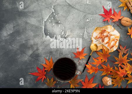Fall leaves with walnuts, cup of coffee and resin art plate with cake on gray background. Thanksgiving day concept. Flat lay, top view Stock Photo