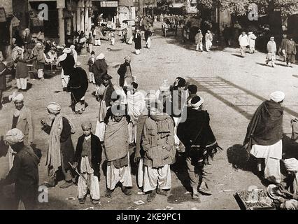 A street scene in Peshwar (Peshawar) , Pakistan circa 1940's before partition. It is known as the City of Flowers (Poshapura) , Parashawar, پېښور. , پشور; and  پشاور and dates back to the 6th century or earlier. It was formerly  the capital of the Indian Kushan Empire Stock Photo