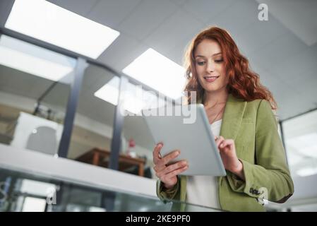 Connected with a simple touch of the finger. a young creative working on a digital tablet in a modern office. Stock Photo