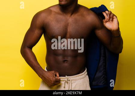 Guy in blue suit on yellow background. Handsome athletic man in jacket smiling Stock Photo
