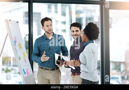 Focused on big ambitions. colleagues having a discussion in an office. Stock Photo
