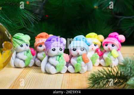 Handmade soap rabbits in bright hats with a flower, the symbol of 2023. Stock Photo