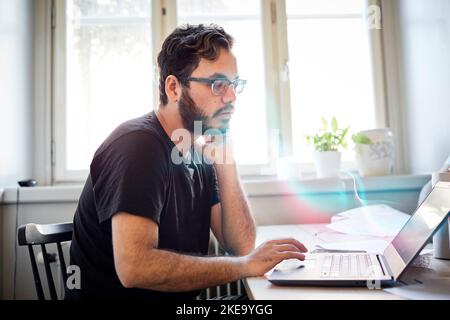 Man reading fake news on computer Stock Photo
