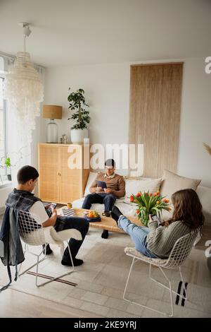 Siblings using phones and tablet at home Stock Photo