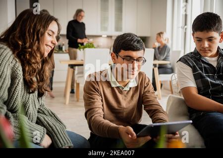Siblings using digital tablet at home Stock Photo