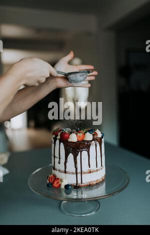 Woman in kitchen decorating cake Stock Photo
