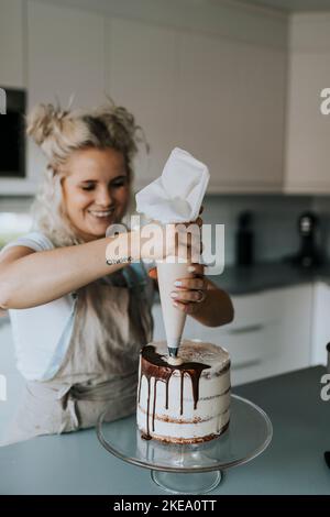 Woman in kitchen decorating cake Stock Photo