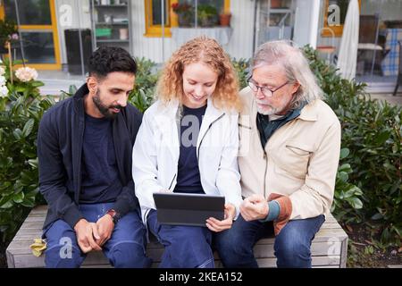 Male and female worker looking at digital tablet in courtyard Stock Photo