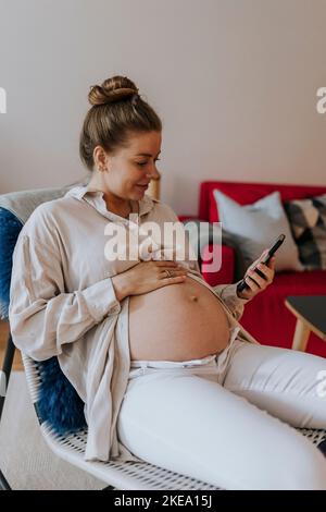 Pregnant woman using cell phone Stock Photo