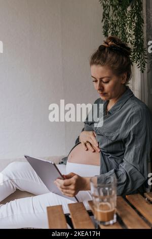 Pregnant woman using digital tablet Stock Photo