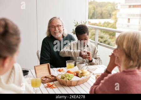 Family sitting at table on balcony Stock Photo