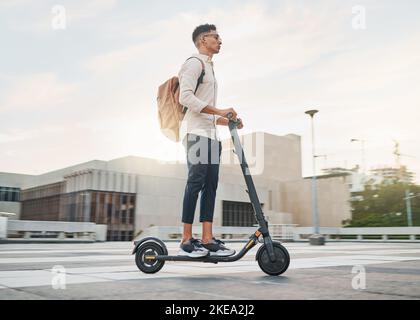 Young man, riding scooter and eco friendly for emission free future, sustainable and outdoor. Travel, casual business man and driving electric Stock Photo