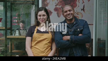 Two happy employees of local small business shop. Young diverse millennials entrepreneurs posing together at camera with arms crossed Stock Photo