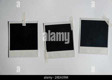 Collection of blank photo frames taped on white wall. Set of photos frame for your picture. Photo frame on a white background Stock Photo