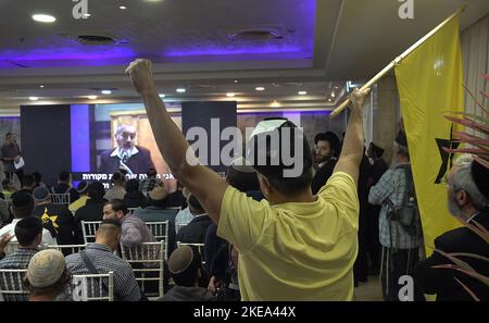 JERUSALEM, ISRAEL - NOVEMBER 10: A far right-wing activist holds up the flag of the outlawed Kach movement, a hard line Israeli militant group that advocates for the expulsion of Arabs from the biblical lands of Israel during a ceremony honoring late Jewish extremist leader Rabbi Meir Kahane, founder of the Kach party on November 10, 2022 in Jerusalem, Israel. Meir Kahane's party Kach, was barred from running for the Israeli parliament as the result of the extremist views the party promoted against Arabs. The United States, also outlawed the Kach movement and categorized it as a terrorist orga Stock Photo