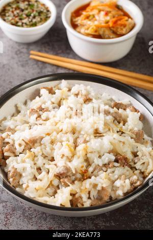 Kongnamul bap is basically rice cooked with soybean sprouts and other ingredients such as meat and kimchi closeup on the table. Vertical Stock Photo