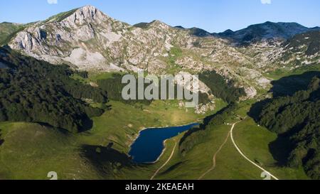Aerial drone view of Orlovacko Lake in Zelengora mountains in Sutjeska National Park. Lake surrounded by mountains. Hiking life and travel. Stock Photo