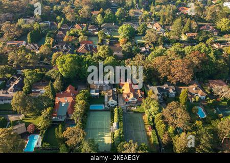 Aerial view of upmarket houses with private gardens, pools, and tennis courts on Sydney's leafy North Shore. Stock Photo