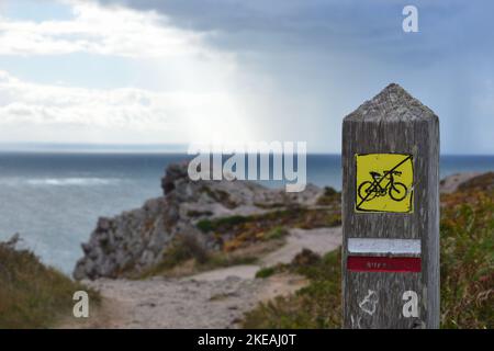 wooden post with trail marker and 'no cycling' sign, France, Brittany, Erquy Stock Photo
