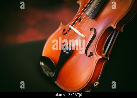Detail view of a violin on a black chair. Stock Photo