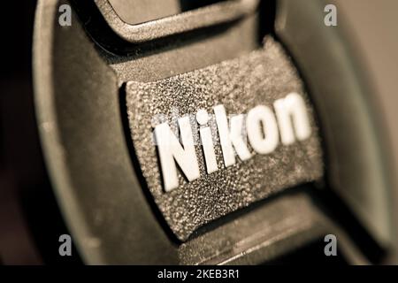 Close-up of a Nikon front lens cover. Foreground and background blurred. Focus on the I letter. Macrophotography o the texture of the plastic surface. Stock Photo