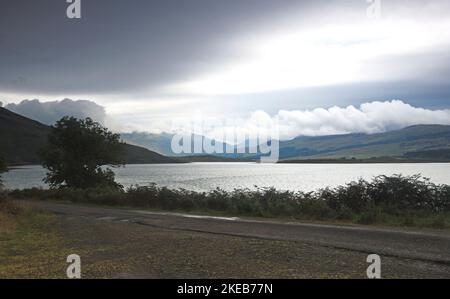 A view from the B8035 road across Loch Scridain and Loch Beg to low cloud over mountains beyond on the Isle of Mull, Argyll and Bute, Scotland. Stock Photo