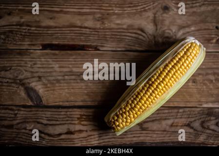 Corn cob (Zea mays) on rustic wooden background. Top view with copy space. Stock Photo