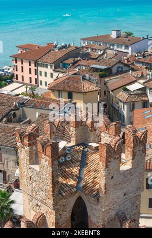 Italian lakes, aerial view in summer across the rooftops of the scenic lakeside town of Sirmione showing a tower of the Scaligero Castle, Lake Garda Stock Photo