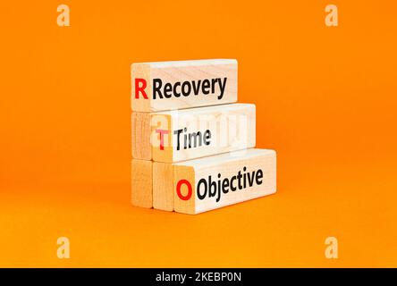 RTO recovery time objective symbol. Concept words RTO recovery time objective on wooden blocks on a beautiful orange background. Business and RTO reco Stock Photo