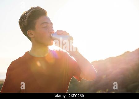 one tired and thirst teenager or man drinking water after a long exercise - adult training to be healthy and fitness Stock Photo