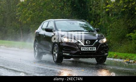 2020 black Nissan Qashqai car driving in the rain on a wet road Stock Photo