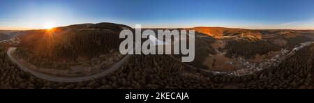 Germany, Thuringia, Goldisthal, village, road, dam, dam wall, largest pumped storage power plant in Germany, forest, mountains, railroad high speed line in background, railroad bridges in background, overview, power lines, sunrise, partly backlight, overview, aerial view, 36ö° panorama Stock Photo