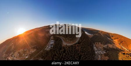 Germany, Thuringia, Goldisthal, village, road, operating building pumped storage power plant, dam, dam wall, forest, mountains, railroad high speed line in background, railroad bridges in background, overview, high voltage lines, sunrise, partly back light, overview, hemisphere panorama Stock Photo