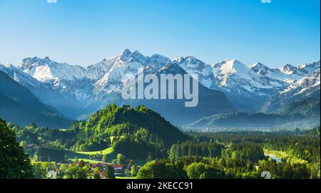 Idyllic mountain landscape on sunny summer day. Forests and snow-covered mountains in Illertal valley near Oberstdorf. Allgäu Alps, Bavaria, Germany, Europe Stock Photo