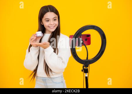 Beauty blog, presenting makeup cosmetics powder and brush. Teen girl speaking in front of camera for vlog. Teenager working as blogger, recording Stock Photo