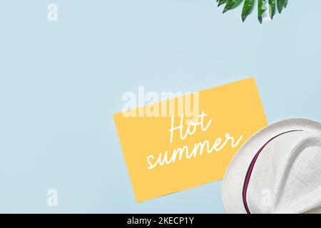a hat with the words it's summer written on it and a yellow post - it note in front Stock Photo