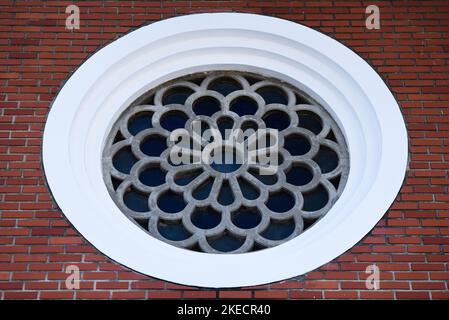 Round Mosaic Decorational Window in the Brick Wall Stock Photo