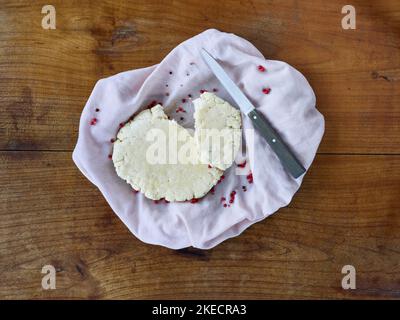ayurvedic cuisine, paneer or home made fresh cheese in a kitchen towel with knife on a wooden table Stock Photo