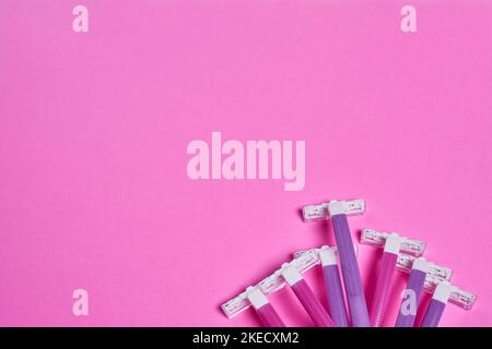 four toothbrushs on a pink background with space for text to be written in the top right corner and bottom left corner Stock Photo