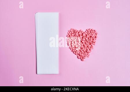 pills in the shape of a heart on a pink background with space for your text, top view stock photo Stock Photo